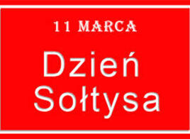 Czerwona tablica z białym napisem: 11 marca Dzień Sołtysa